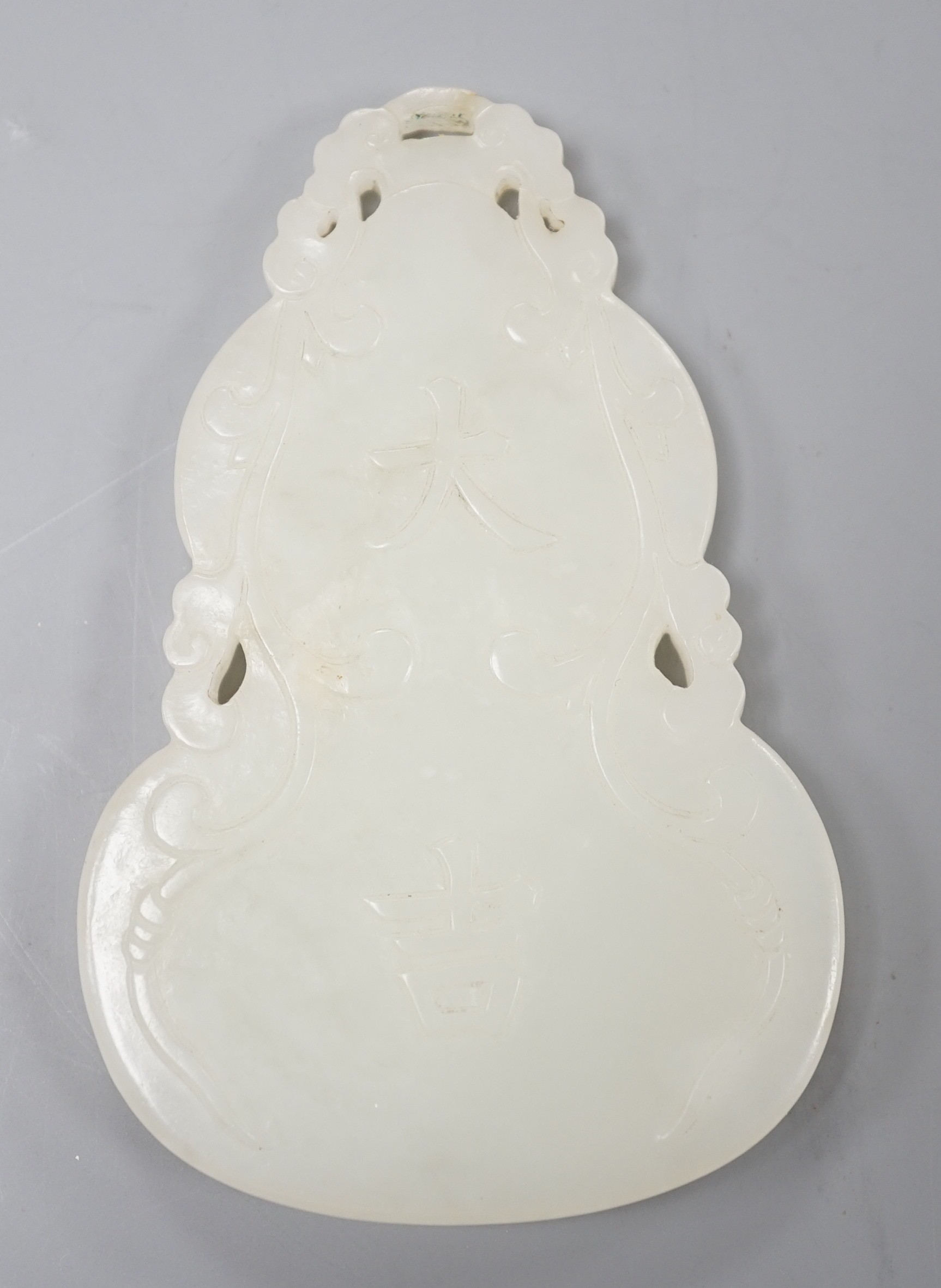 A Chinese inscribed white jade gourd shaped plaque on stand, with calligraphy, 12cms high.